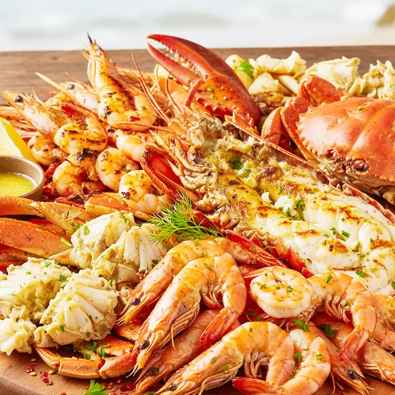 Prato com diferentes crustáceos, incluindo camarões, caranguejos e lagosta, alimentos associados à reação cruzada em pessoas com alergia a camarão