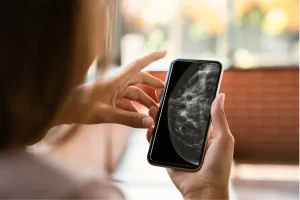 Moça obervando o resultado de seu exame na tela do seu celular, no conforto de sua casa.